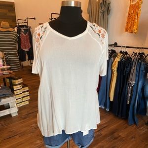 White top with orange embroidered flowers